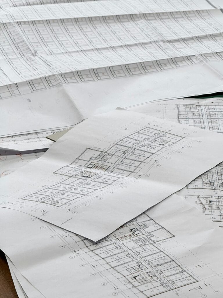 Project plans and blueprints spread out for procurement planning